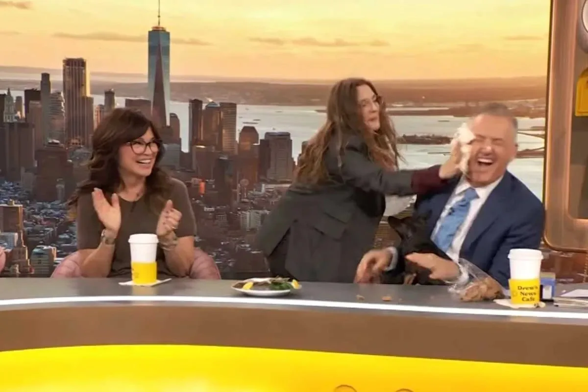 Drew Barrymore joga bolo no rosto de Ross Mathews durante programa